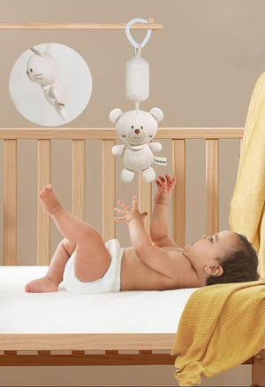 Baby lying in crib with hanging teddy bear toy, text about scientific perspective.
