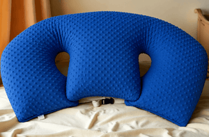 Blue U-shaped pillow on a bed