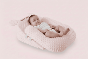 Baby lying on a pink textured pillow with a soft background