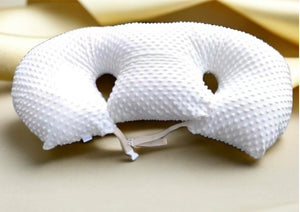 White textured neck pillow on a beige surface