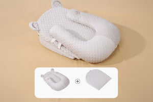 Baby nest with U-shaped pillow on a beige background