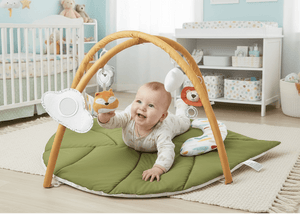 Baby playing with toys on a green mat in a nursery room.