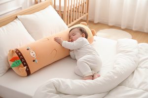 Long cylindrical plush toy with cartoon face on a couch