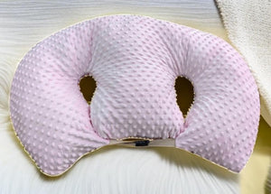 Pink textured neck pillow on a light background