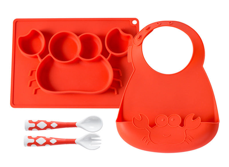 Red silicone baby tray with compartments, red bib with a cat design, red and white spoons, and red and white fork on a white background.