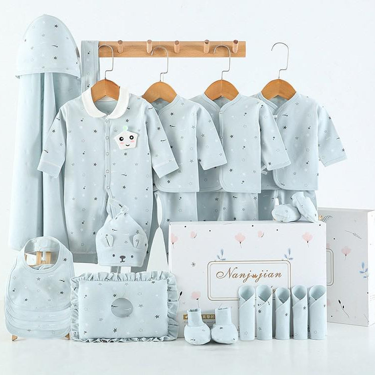 Collection of baby clothing and accessories on hangers with a branded box in the background.