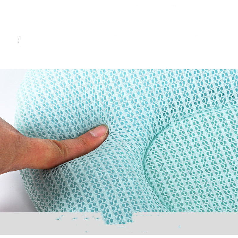 Hand pressing down on a textured green surface with a white background
