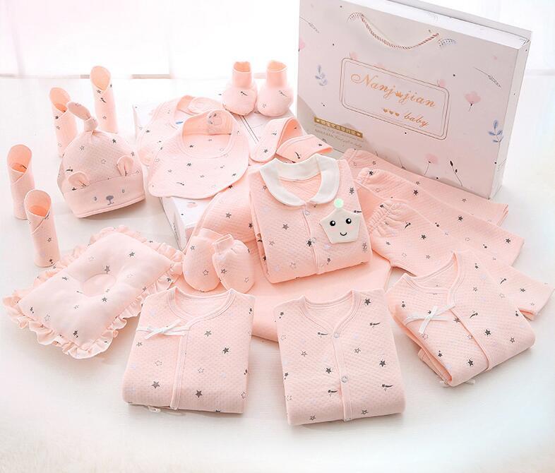 Collection of pink baby clothes and accessories on a white background