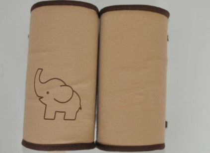 A baby lying on a safety support pillow designed to prevent rolling over, featuring gray color with red trim and a white embroidered design.