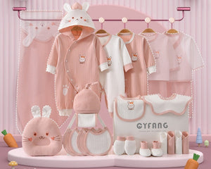 Baby clothing set with pink outfit, hat, and accessories on a pink background with bunny ears.
