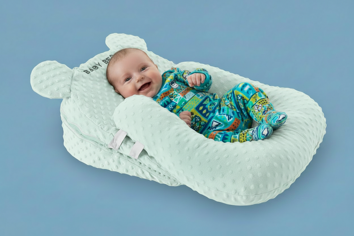 Baby in a white bear-shaped baby nest on a blue background