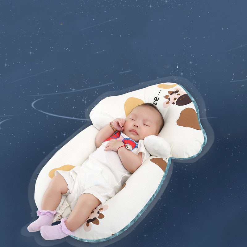 Baby sleeping in a cow-shaped pillow against a starry night sky background