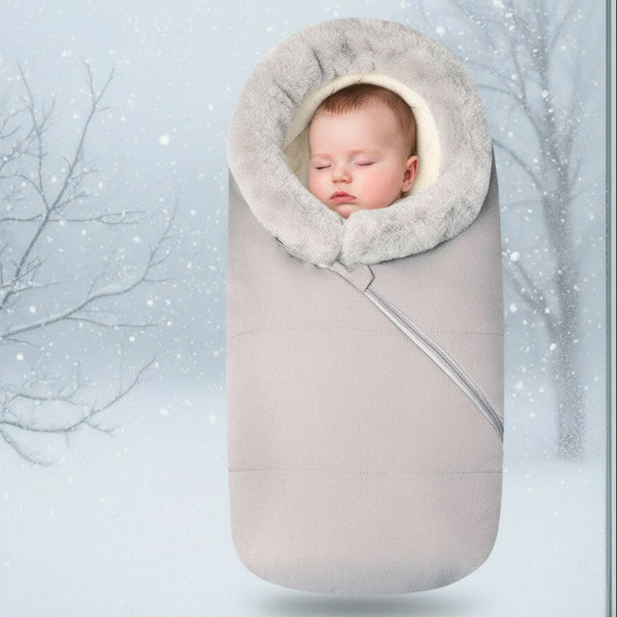 A baby sleeping bag with a gray color and a removable fur collar, zipped into a stroller, keeping the baby warm and protected.