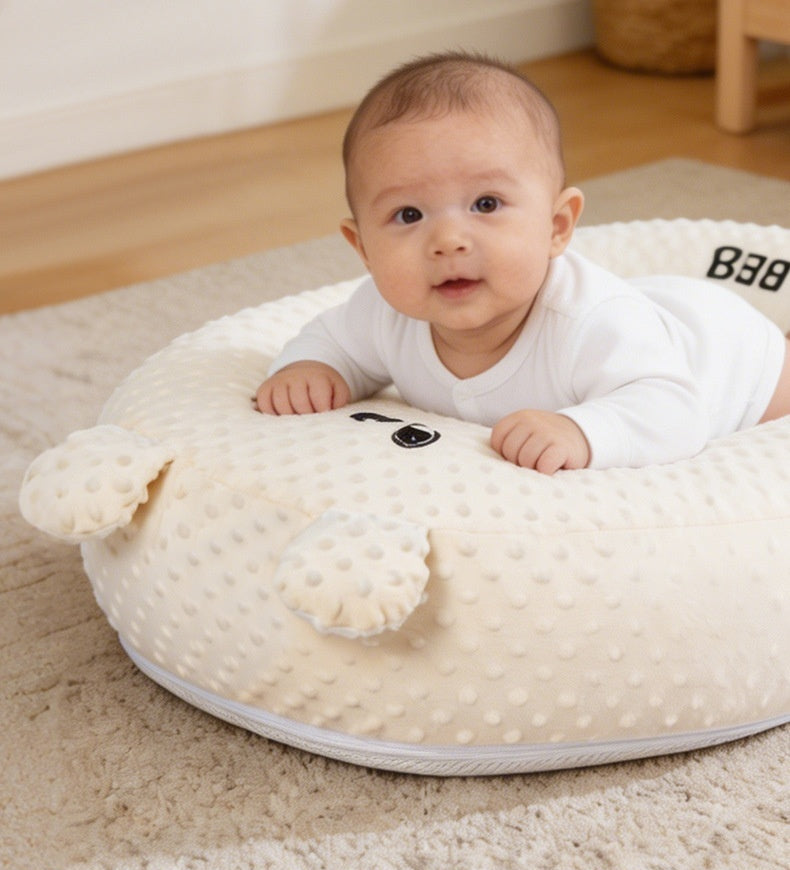 Baby lying on a tummy time pillow with text about its benefits