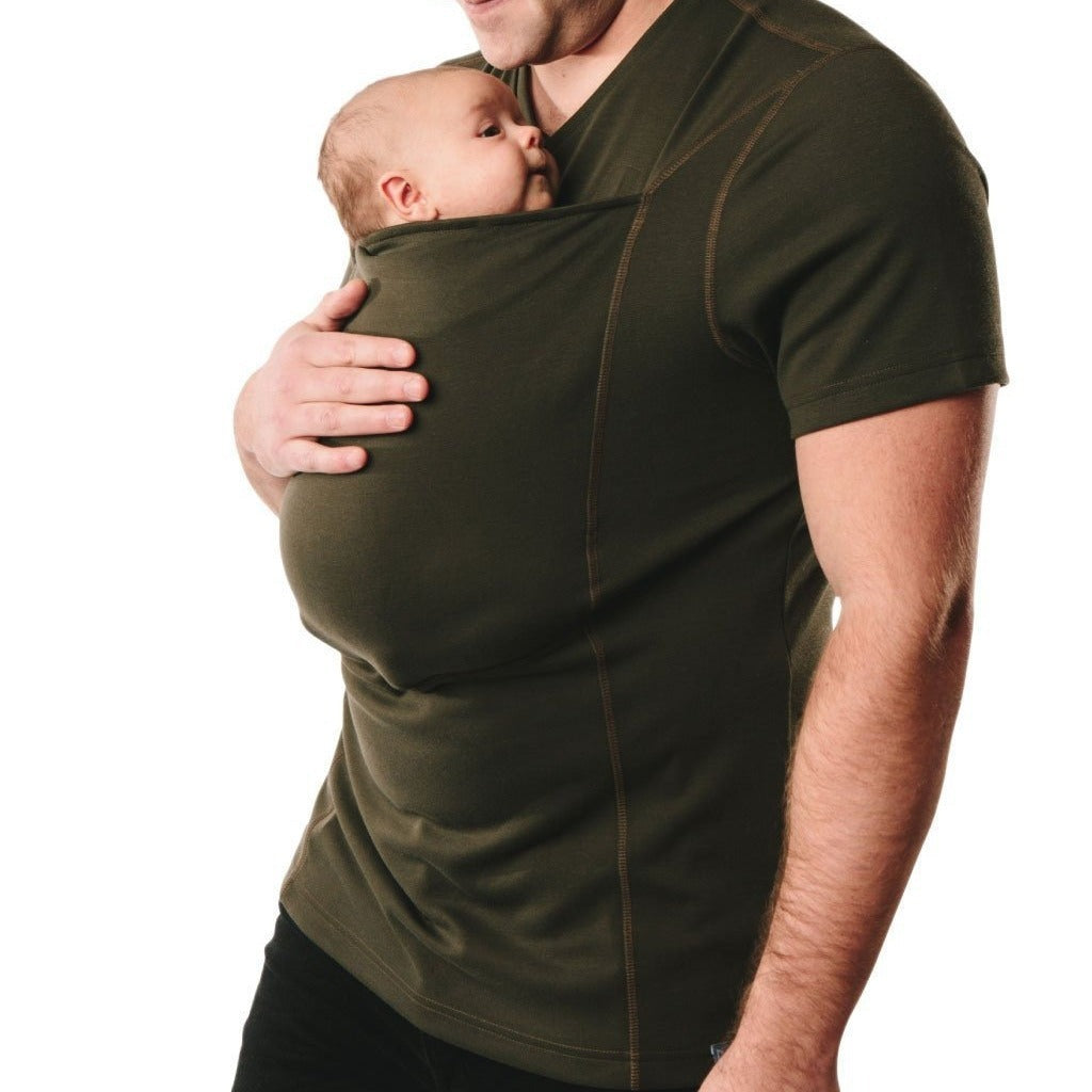 Man wearing a green shirt with a baby carrier built into the design, holding a baby.