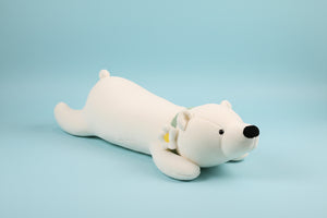 White plush toy dog lying on a textured surface with a blurred background