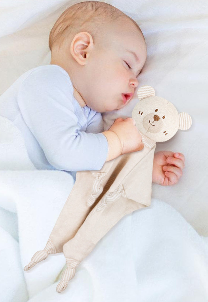 Baby sleeping with a soft toy, surrounded by organic cotton soothing towel.