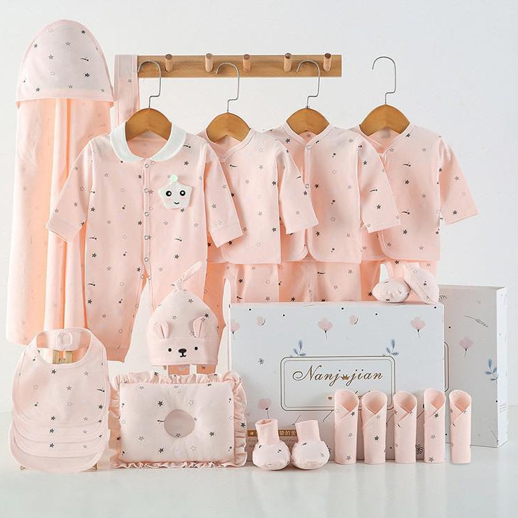 Baby clothing set with pink outfits, accessories, and a canopy on a white background.