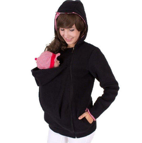 Woman wearing a black hoodie with a baby carrier on a white background
