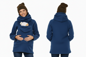 Woman wearing a blue hoodie with a front pocket, brown beanie, and holding a baby in a carrier on a white background.