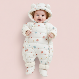 Baby wearing a white snowsuit with colorful patterns on a beige background