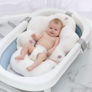 Baby lying on a soft, star-patterned cushion in a white crib with gray accents.