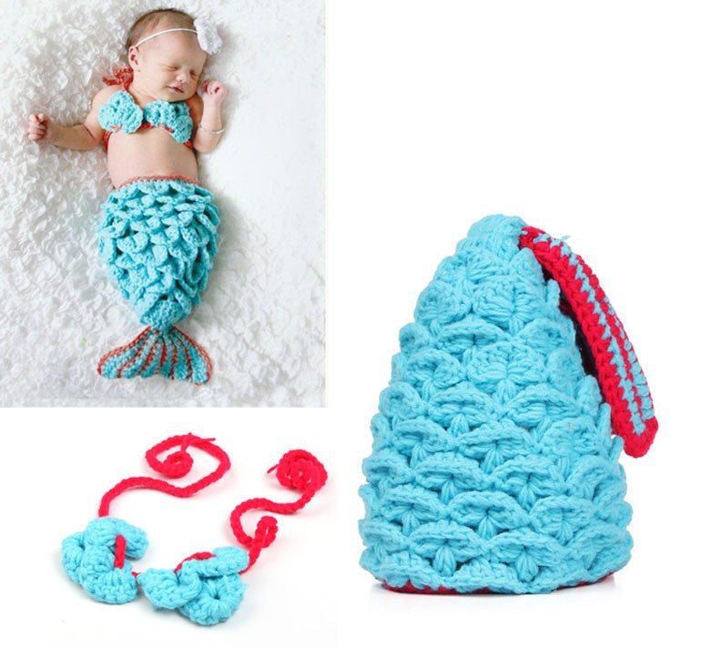 Baby in mermaid costume with crochet tail, top, and necklace on a white background