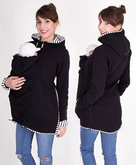 Woman wearing a black hoodie with a baby carrier feature, shown from front and back views.