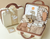 Baby gift set with toys and clothes in a suitcase on a beige background