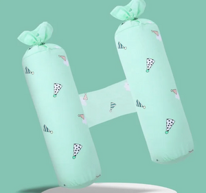 Two green cylindrical pillows with decorative bows on a light green background