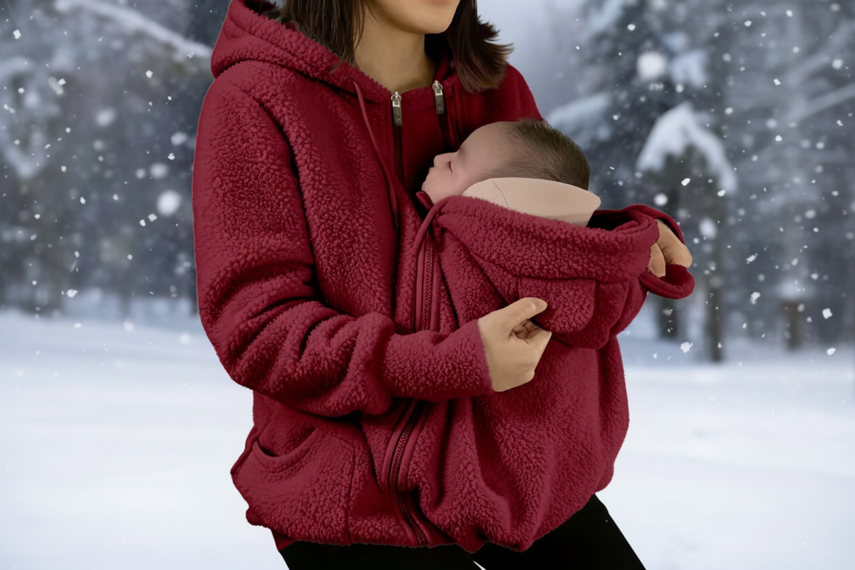 Person wearing a red fleece jacket holding a baby in a snowy setting with a flame icon indicating warmth.