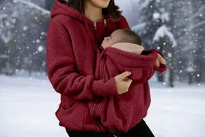 Person wearing a red fleece jacket holding a baby in a snowy setting with a flame icon indicating warmth.