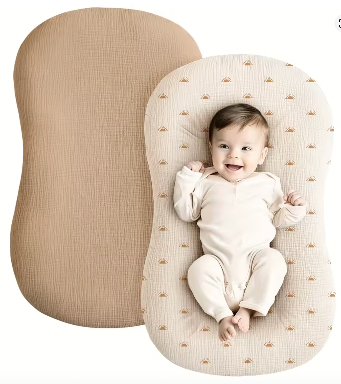 Baby lying on a textured beige cushion with a plain beige cushion next to it.