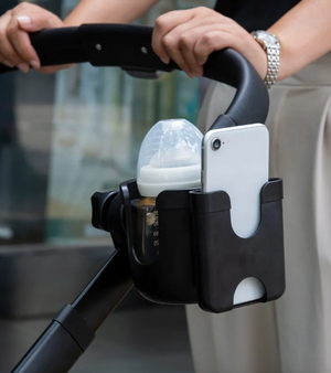 Stroller organizer holding a bottle and phone with a blurred background
