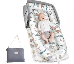 Baby lying on a patterned mat with a gray bag next to it