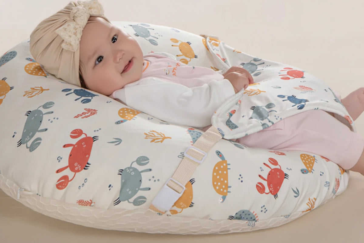 Baby lying on a wedge-shaped pillow with a 15-degree angle, wearing a patterned outfit and headband.