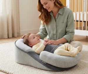 Woman sitting on a cushion with a baby on her lap in a home setting