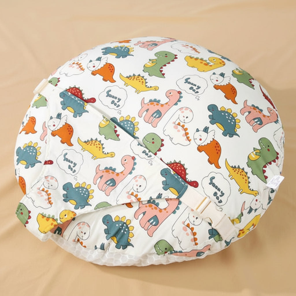 A round baby blanket or cushion cover featuring a colorful cartoon dinosaur pattern on a white background, displayed on a beige fabric surface 
