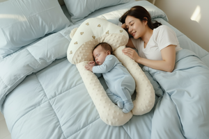 Newborn baby sleeping in a white crescent moon-shaped crib on a bed.