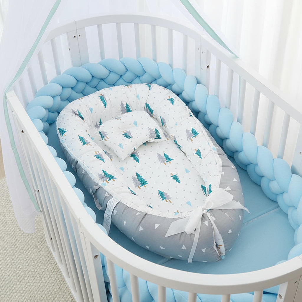 Baby nest with tree pattern in a crib with blue bedding