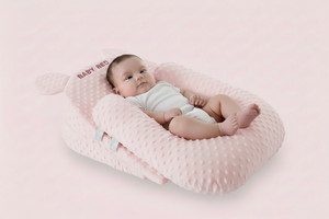 Baby lying on a pink textured pillow with a soft background