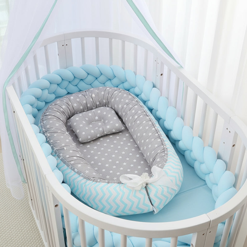 Baby crib with pink bumper and gray polka dot mattress