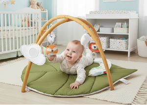 Baby playing with toys on a green mat in a nursery room.