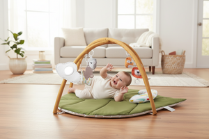 Baby playing with a green activity gym on a white floor