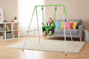 Child in a green swing set in a living room with a couch and shelves.